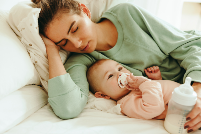 Mère endormie près de son bébé