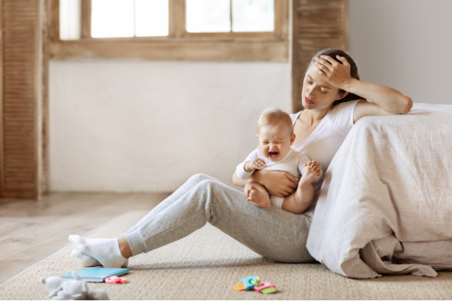 Maman dépassée avec son bébé dans les bras