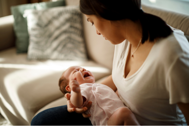 Un bébé pleurant dans les bras de sa maman