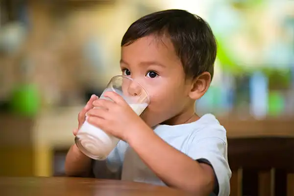 Jeune enfant buvat un verre de ait